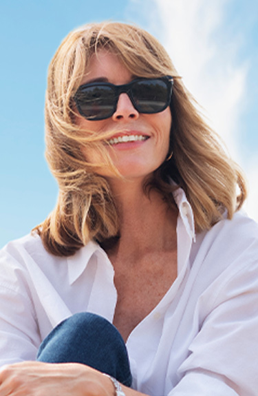 Smiling woman in sunglasses outdoors, mobile banner for facial volume loss